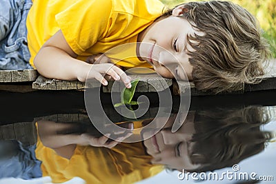 Boy play with autumn leaf ship in water, children in park play w Stock Photo