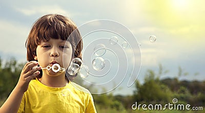 Boy play in bubbles in sunny summer day Stock Photo