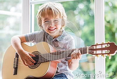 Boy playing acoustic guitar Stock Photo