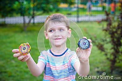 Boy playing with a beyblade spinning top outdoors Stock Photo