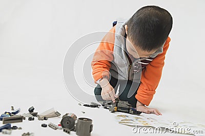 Boy playing bricks toy with instruction Stock Photo