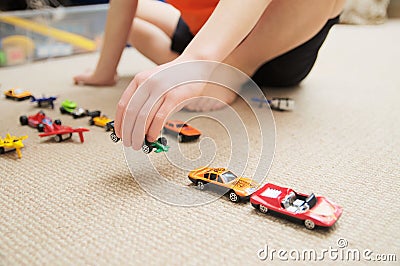 Boy playing with car collection on carpet.Child hand play. Transportation, airplane, plane and helicopter toys for children Stock Photo