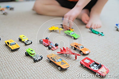 Boy playing with car collection on carpet.Child hand play. Transportation, airplane, plane and helicopter toys for children Stock Photo