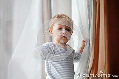 Boy playing with curtains Stock Photo