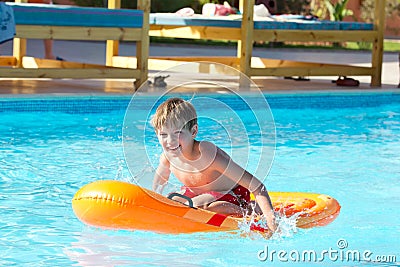 Boy playing on dingy in pool Stock Photo