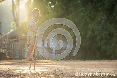 A boy playing Gong Keng is a Thai traditional toy that uses bamboo to make two legs to walk Editorial Stock Photo