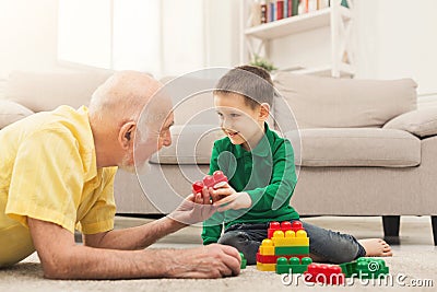 Boy playing with grandfather in building kit Stock Photo