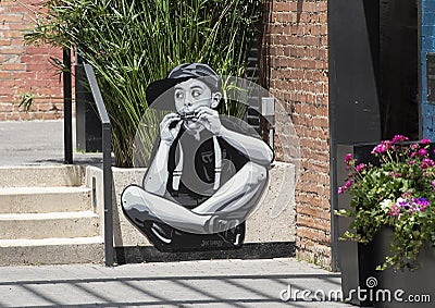 Boy playing a harmonica by multidisiplinary artist Joe Iurato in Deep Ellum in East Dallas, Texas. Editorial Stock Photo