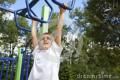 Boy playing on monkey bars Stock Photo