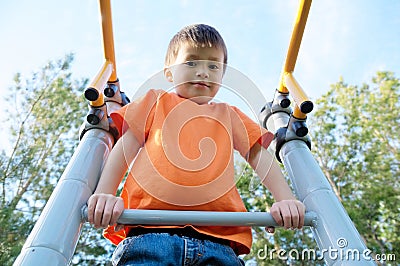 Boy playing outdoors on bar gym. Kid on playground,children activity. Child having fun. Active healthy childhood Stock Photo