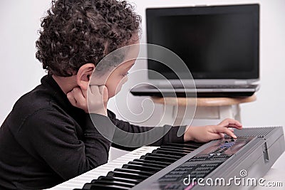 Boy playing the piano keyboard stock photo Stock Photo