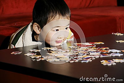 Boy playing puzzle game Stock Photo