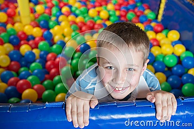 A boy in the playing room with many little colored balls Stock Photo