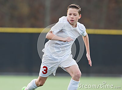 Boy playing soccer in game Stock Photo
