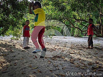 A boy is playing soccer under a tree in their yard while doing the famous soccer player style after scoring a goal. Editorial Stock Photo