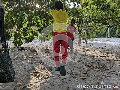 A boy is playing soccer under a tree in their yard while doing the famous soccer player style after scoring a goal. Editorial Stock Photo