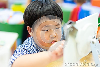 A boy is playing and studying with a tablet in library Stock Photo