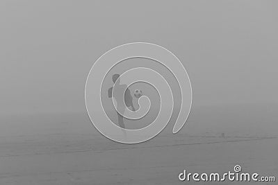 Boy plays football in the fog Stock Photo