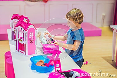 The boy plays with girl toys and dolls Stock Photo