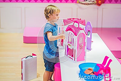 The boy plays with girl toys and dolls Stock Photo