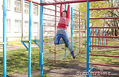 A boy plays outdoors on the playground. Stock Photo
