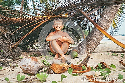 Boy plays in Robinzon on tropical beach in hut of branches Stock Photo