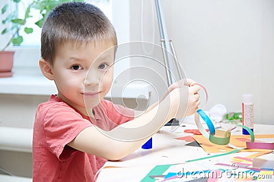 Boy portrait playing with paper, child crafting activity Stock Photo