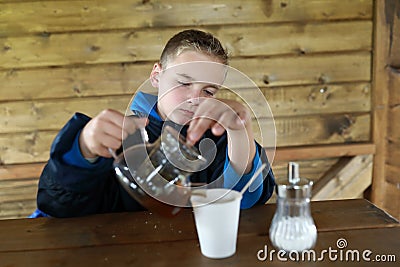 Boy pouring herbal tea Stock Photo