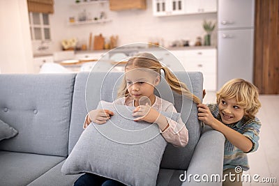 Boy pulling girls ponytail from behind and smiling Stock Photo