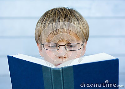 Boy reading blue book Stock Photo