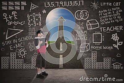 Boy reading book with chalkboard and success road Stock Photo