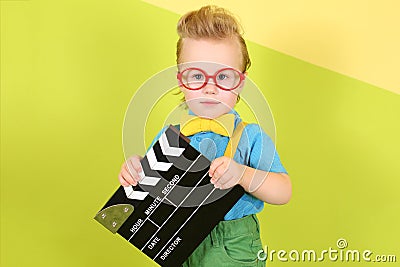 A boy in red big glasses with a clapstick in his Stock Photo