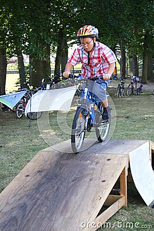 Boy rides his bike over a ramp during skill training Stock Photo