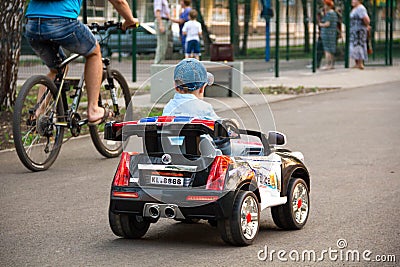 A boy rides a toy car in the Park Editorial Stock Photo