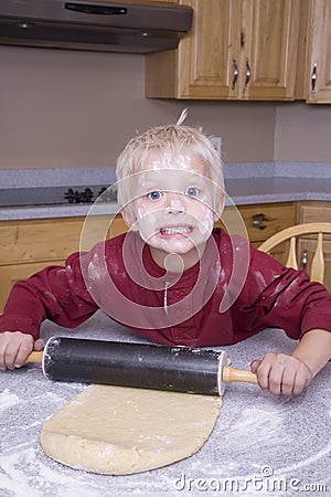 Boy rolling out dough Stock Photo