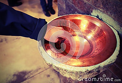 hand dip in the blessed stoup water in Basilica and vintage old Stock Photo