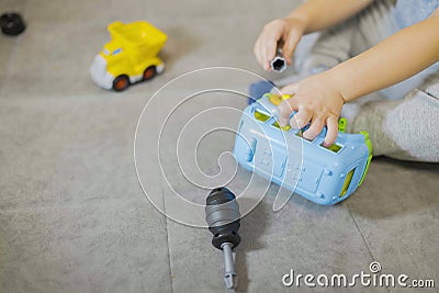 The boy`s hands with a screwdriver fixes a toy car-constructor Stock Photo