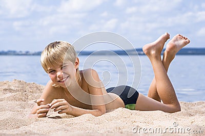 Boy in sand on seashore Stock Photo