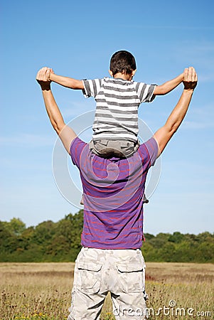 Boy sat on his fathers shoulders Stock Photo