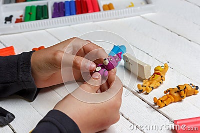 Boy sculpts from wax modeling clay figures of animatronics heroes of computer games, comics Stock Photo