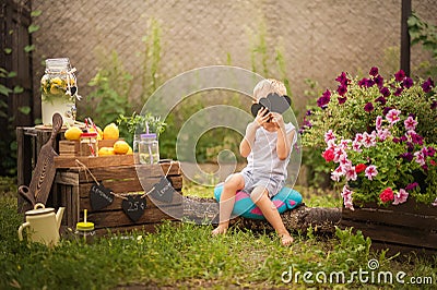 Boy sells homemade lemonade close-up and copy space. The boy in the summer makes homemade lemonade. Children`s games with lemonade Stock Photo