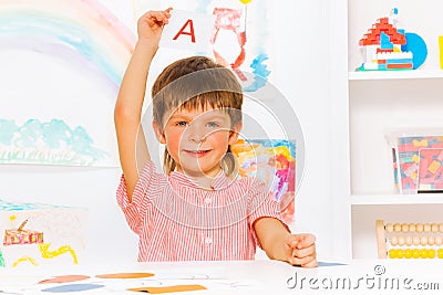 Boy showing letter flashcard in reading class Stock Photo