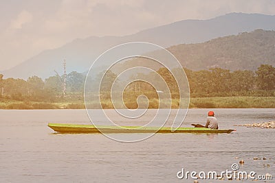 Boy sit in old boat park in river bay. Editorial Stock Photo