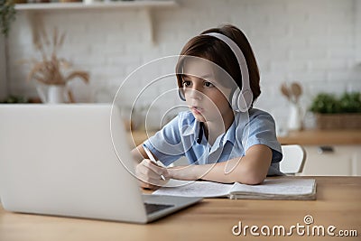 Boy sit at table studying at home online use laptop Stock Photo