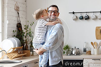 Boy sitting on fathers hands and kissing cheek Stock Photo