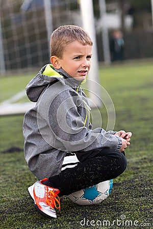 Boy Sitting on Soccer Ball Stock Photo