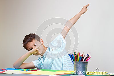 Boy sitting at the table and shows dab gesture Stock Photo