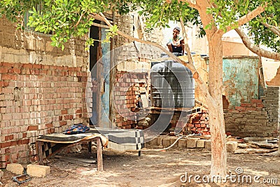 Boy sitting on top of water tank Editorial Stock Photo