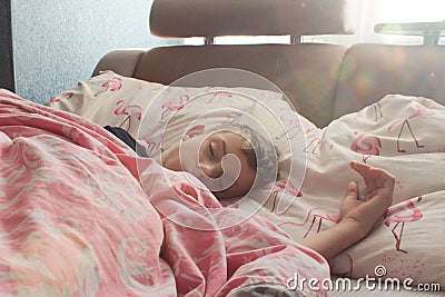 the boy sleeps in a pink bed in a sound morning sleep under the sun& x27;s rays Stock Photo