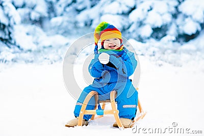 Boy on sleigh ride. Child sledding. Kid with sledge Stock Photo